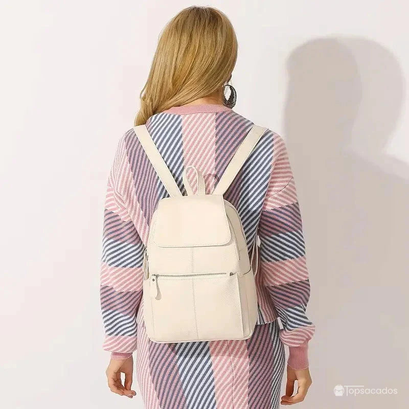 sac à dos ville femme beige porté sur le dos par une femme vêtue d’un pull coloré à rayures, fond neutre intérieur