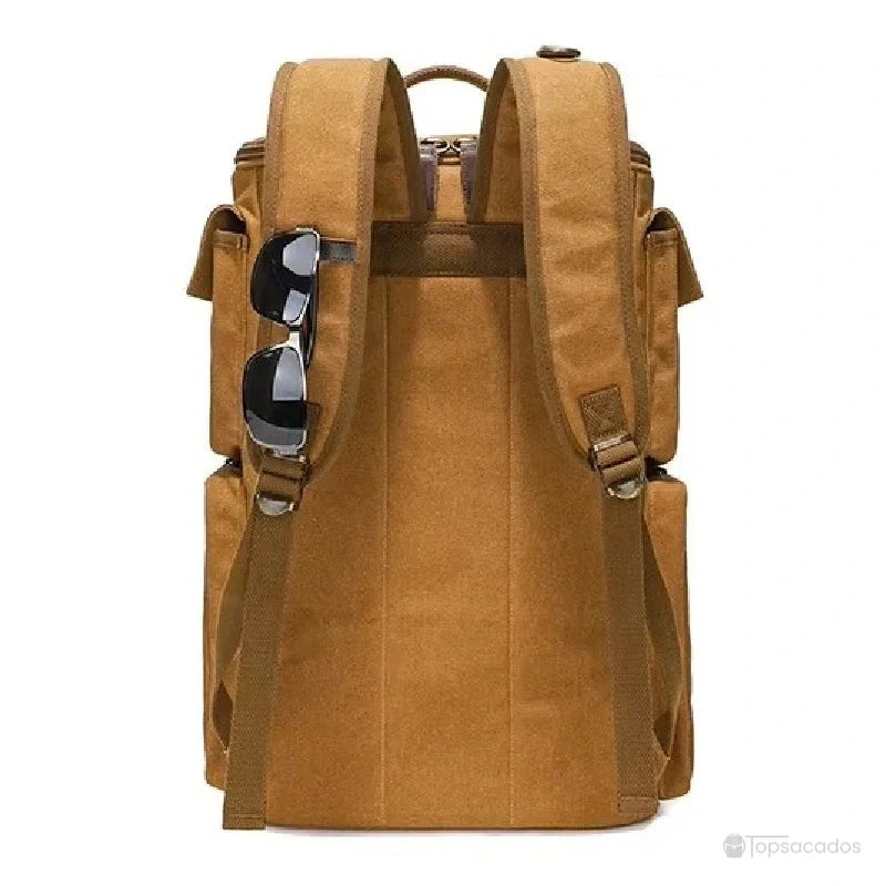 Sac à dos vintage marron vu de dos avec lunettes accrochées aux bretelles, fond clair