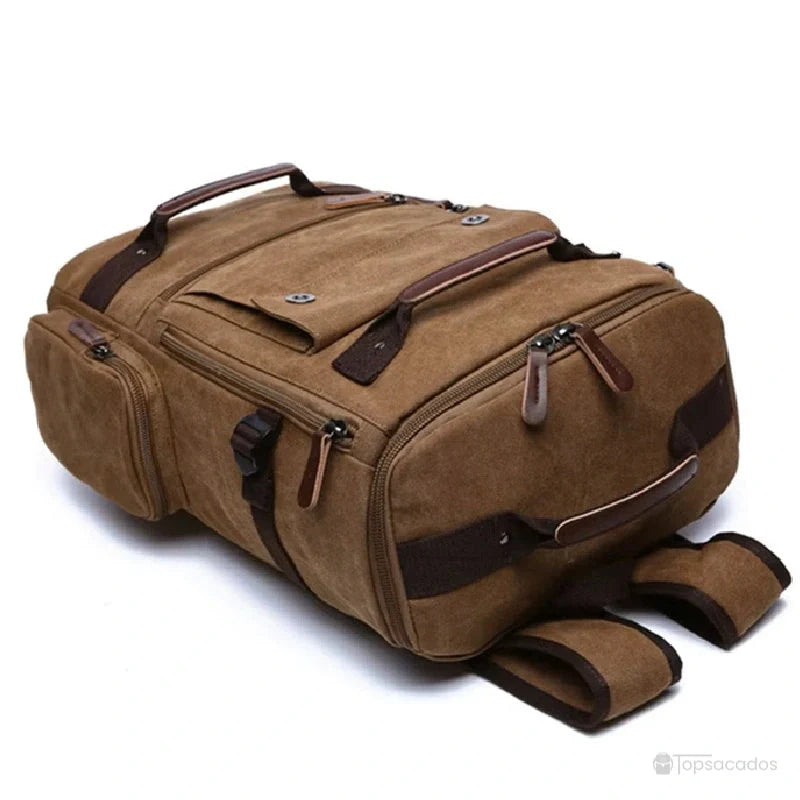 Sac à dos vintage homme en toile marron vu à plat, avec poches zippées et détails en cuir, sur fond blanc.