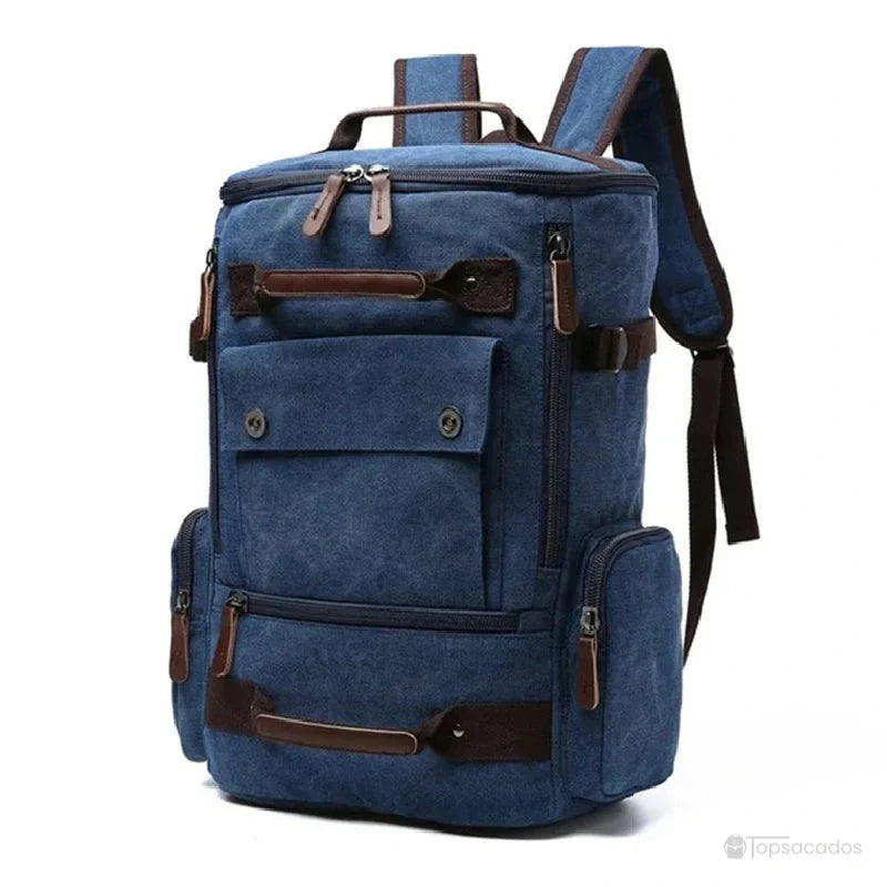 Sac à dos vintage homme bleu foncé en toile robuste, avec multiples poches et détails en cuir, présenté de face.