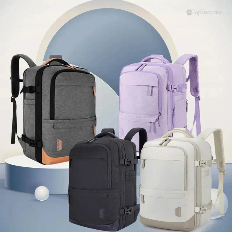 Sac à dos voyage extensible décliné en quatre coloris – gris, violet, noir et beige – présentés sur un socle décoratif dans un décor épuré et moderne.