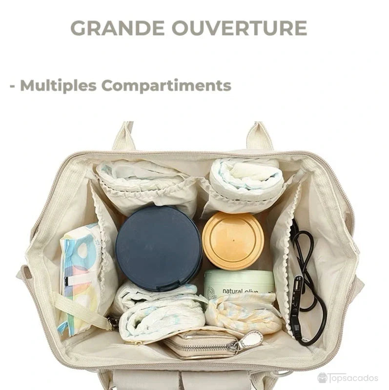 Sac à langer à dos vu de haut, grande ouverture avec compartiments organisés pour accessoires de bébé.