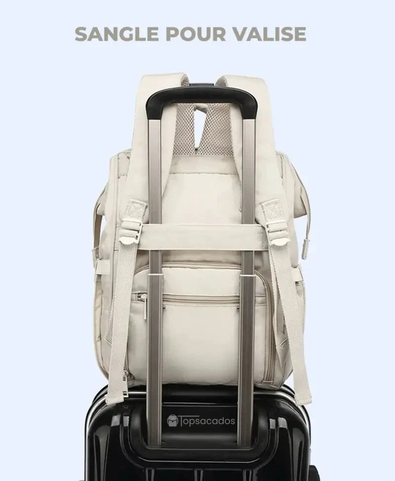 Sac à langer à dos fixé à une valise grâce à la sangle arrière prévue pour les voyages.