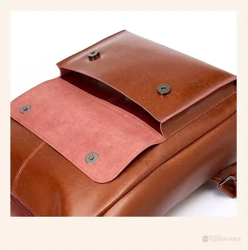 Sac à dos vintage pour femme avec rabat aimanté ouvert, montrant la doublure intérieure rose et les boutons pression pratiques pour une fermeture sécurisée.