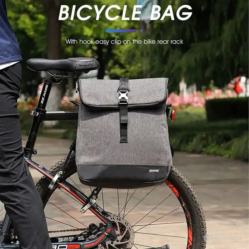 Sacoche vélo Sac à dos accrochée au porte-bagages d’un VTT stationné dans un parc, mise en avant de sa fonction clip rapide