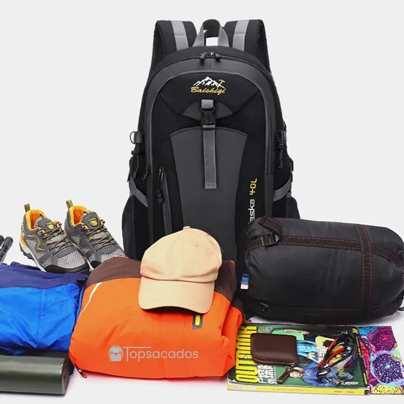 Sac à dos 40L Randonnée - Contenu affiché avec équipements de trekking : veste imperméable, chaussures, sac de couchage, magazines outdoor, accessoires et vêtements, sur fond clair