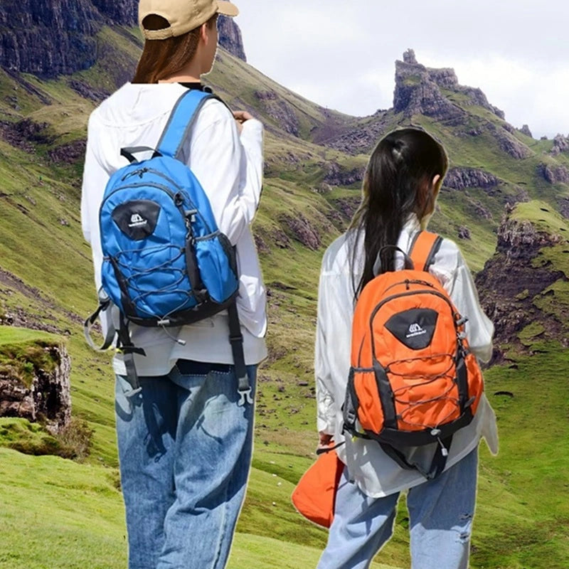 Petit Sac à dos randonnée femme porté en pleine montagne par deux randonneuses, l’une avec un sac bleu, l’autre orange, dans un paysage vert.