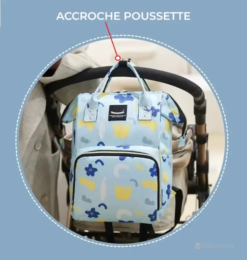 Sac à dos à langer accroché à une poussette à l’aide d’un crochet intégré, illustrant une solution pratique pour les sorties avec bébé.