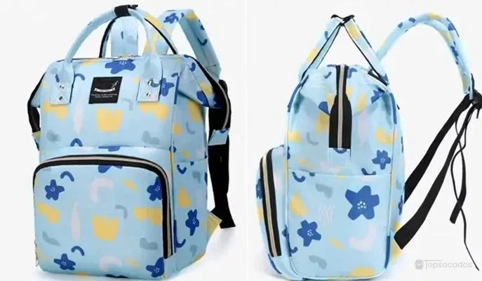 Sac à dos à langer vu de près avec tissu waterproof bleu imprimé de fleurs jaunes et bleues, des gouttes d’eau visibles en surface.