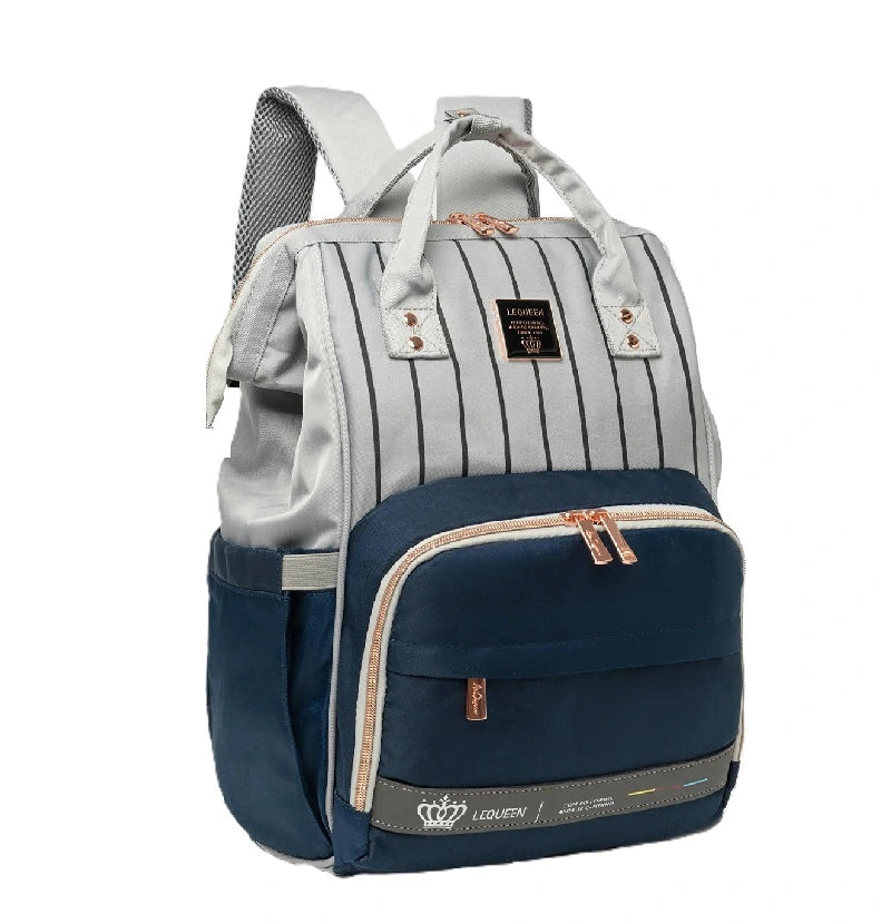Sac à dos à langer Urbain et chic bleu avec rayures verticales et poche avant zippée, posé sur fond blanc.