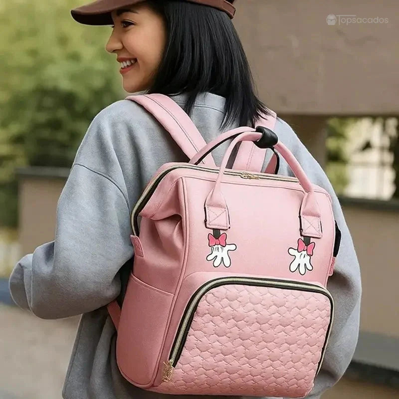 sac-a-dos-bebe-avec-son-prenom porté par une femme souriante, en extérieur, couleur rose