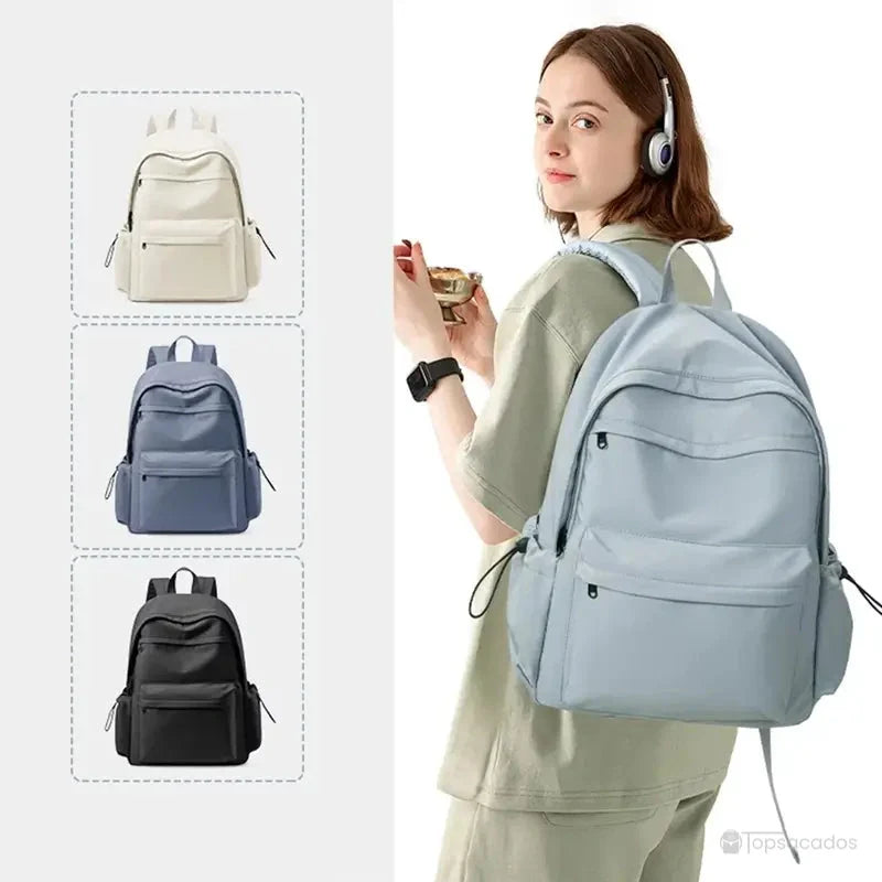 Sac à dos collège fille décliné en beige, violet, noir et bleu clair, porté par une étudiante avec casque audio.