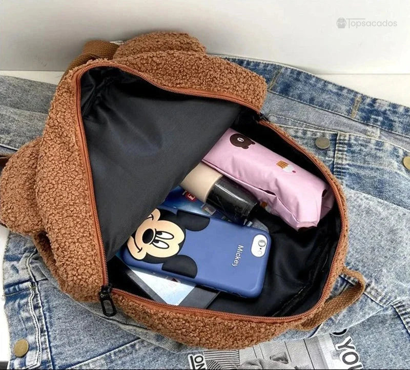 Sac a dos college Ourson ouvert montrant son interieur spacieux avec objets du quotidien sur fond de veste en jean