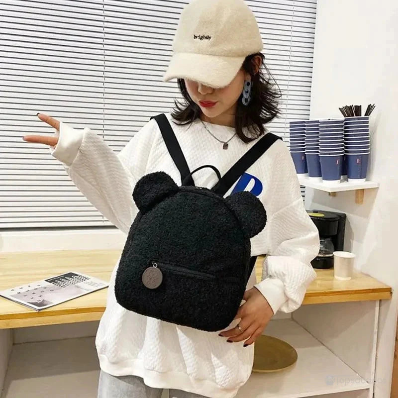 Sac a dos college Ourson noir porté par une jeune femme en intérieur moderne, ambiance urbaine et décontractée