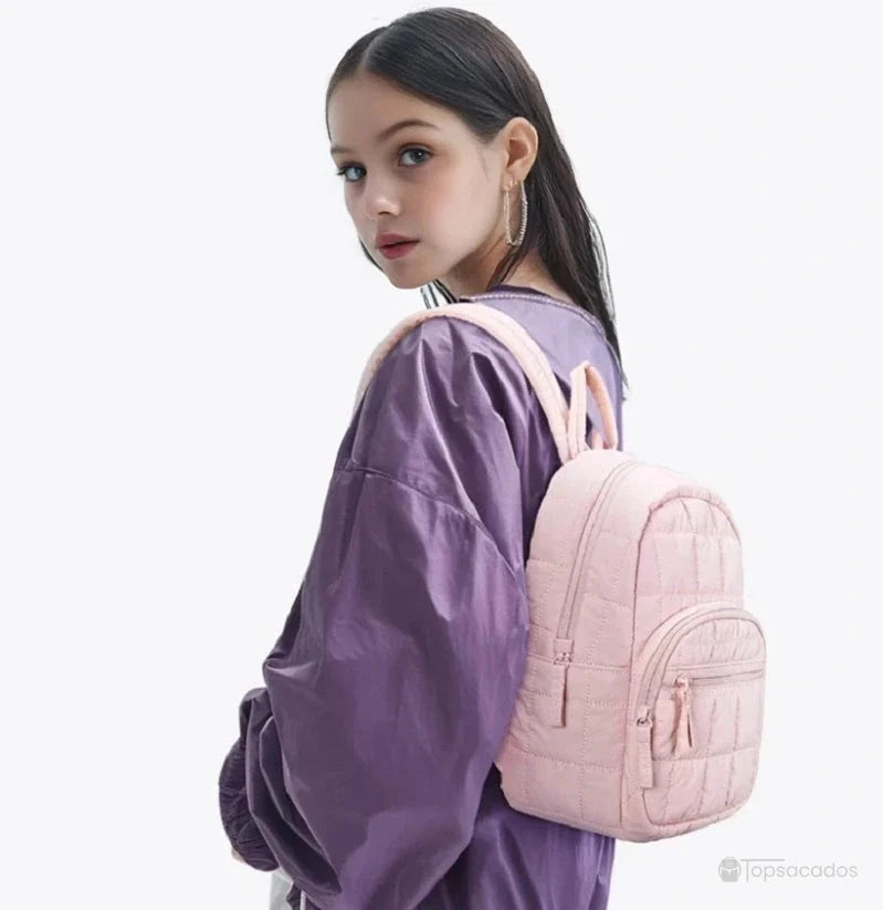 sac à dos college rose porté par une jeune femme en veste violette sur fond clair