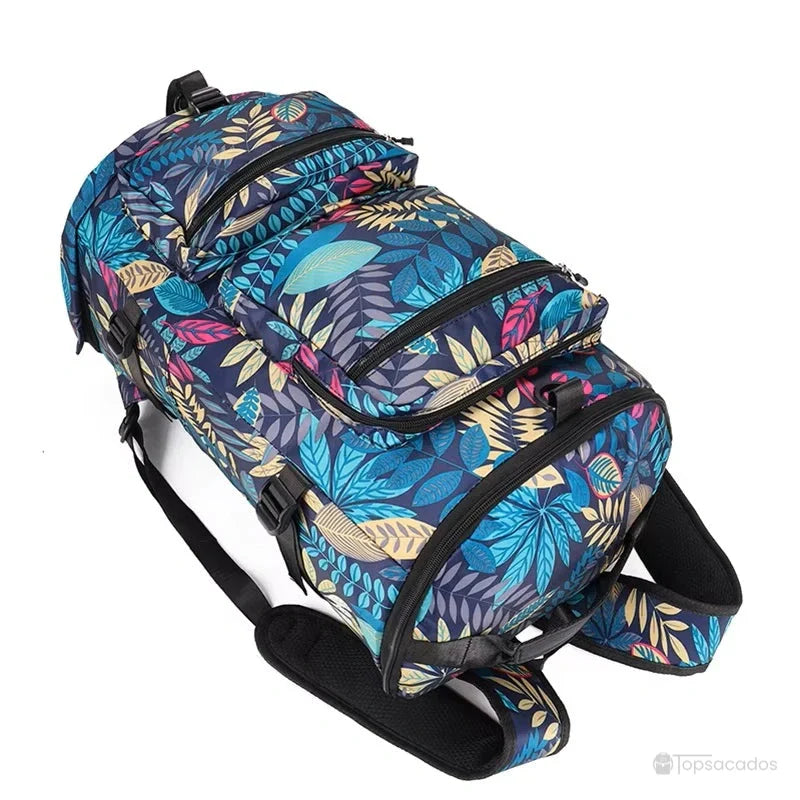 Sac à dos compartiment chaussure à motif feuillage posé au sol vu en perspective, mettant en valeur son volume généreux