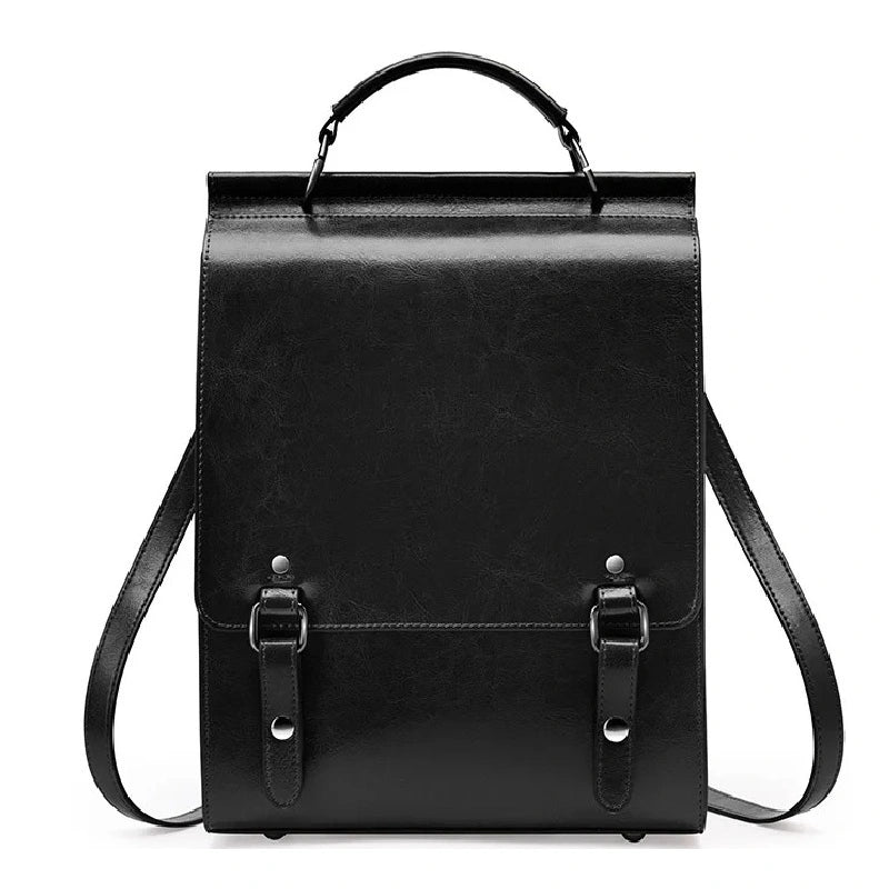 Sac à dos cuir Femme avec rabat noir en cuir rigide, posé sur fond blanc, avec poignées et sangles visibles