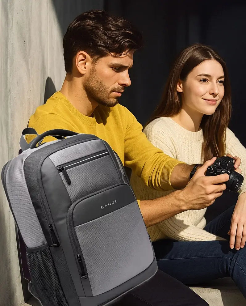 Sac à dos de cours gris et noir porté par un homme assis à côté d’une femme, tous deux en tenue décontractée à l’extérieur