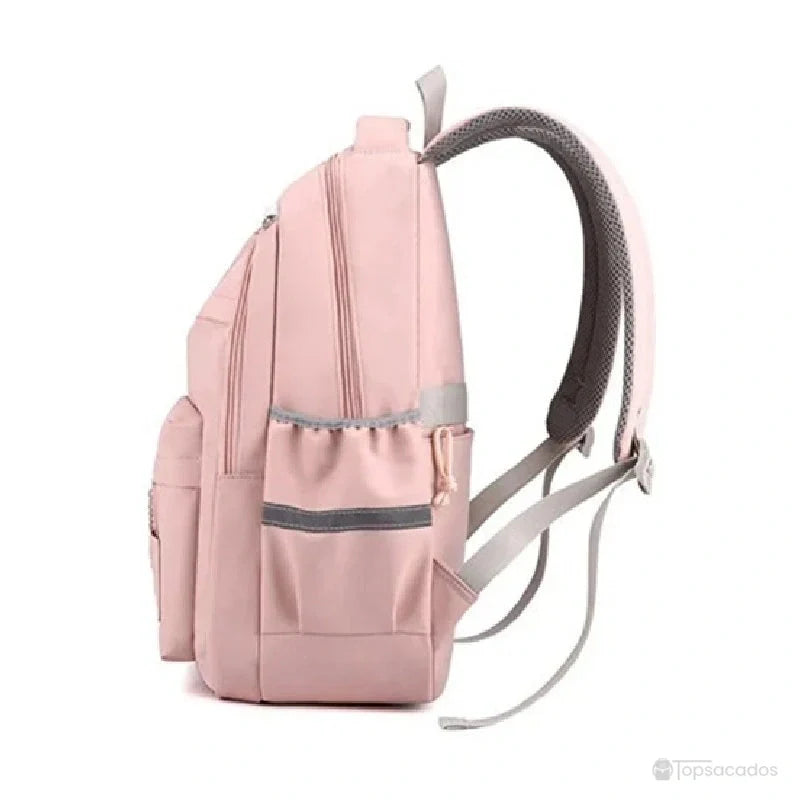 Sac à dos école rose pastel vu de profil avec poches latérales élastiques et bretelles ajustées.
