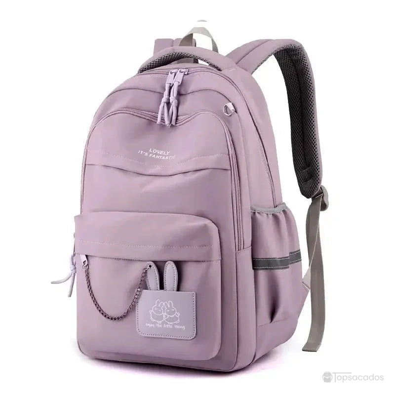 Sac à dos école violet spacieux avec décoration amusante et grande poche avant, fond blanc.