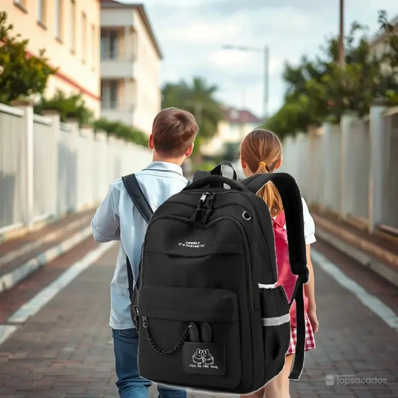 Sac à dos école noir porté par deux enfants marchant dans la rue en direction de l’école, environnement extérieur.