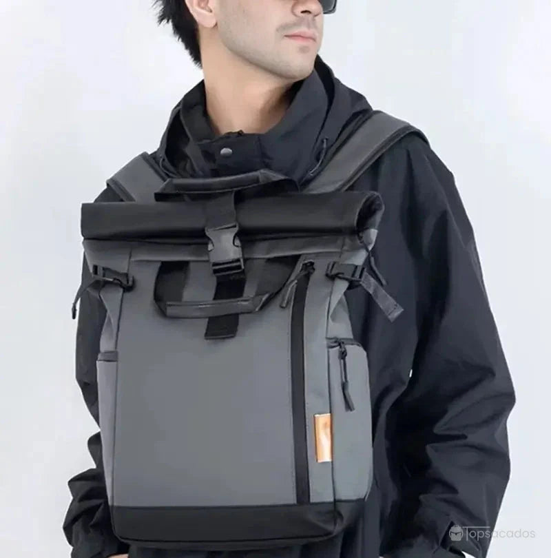 Sac à dos étanche porté sur le torse par un homme en tenue noire, soulignant le confort et la polyvalence du port frontal.