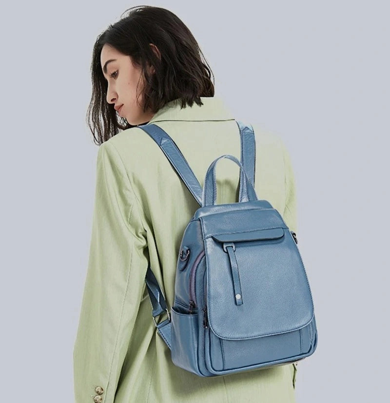 Sac à dos femme élégant bleu clair porté sur le dos par une femme en veste verte, élégant et pratique