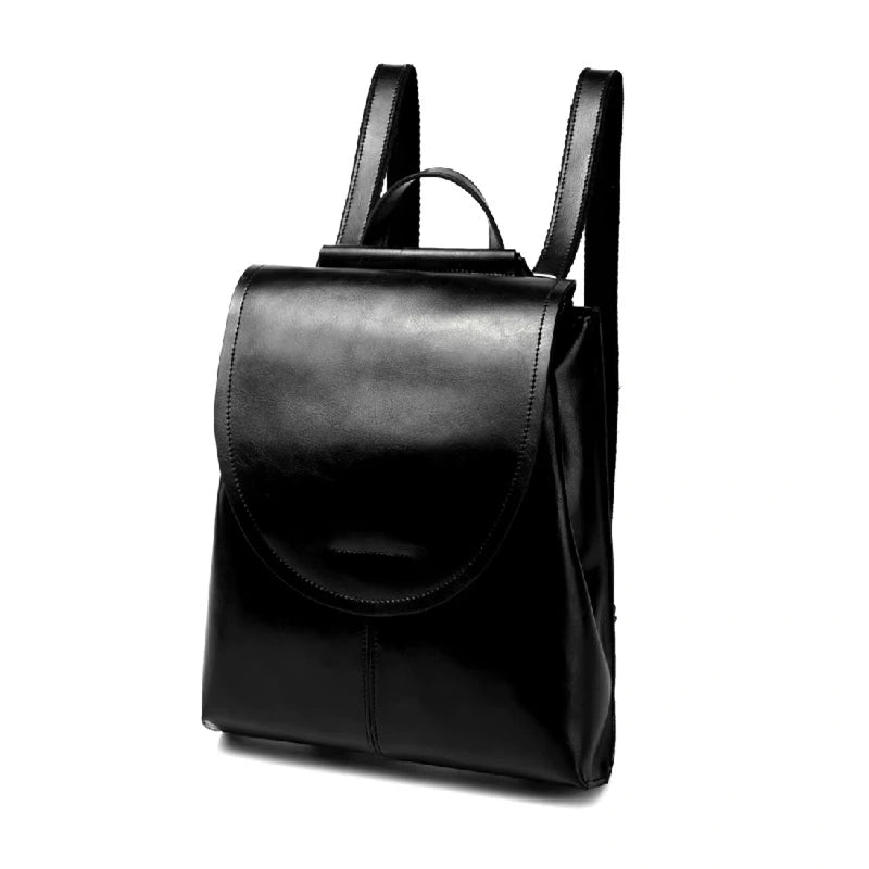 Sac à dos femme en cuir noir élégant en position debout sur fond blanc, mettant en valeur son rabat arrondi et ses bretelles solides.