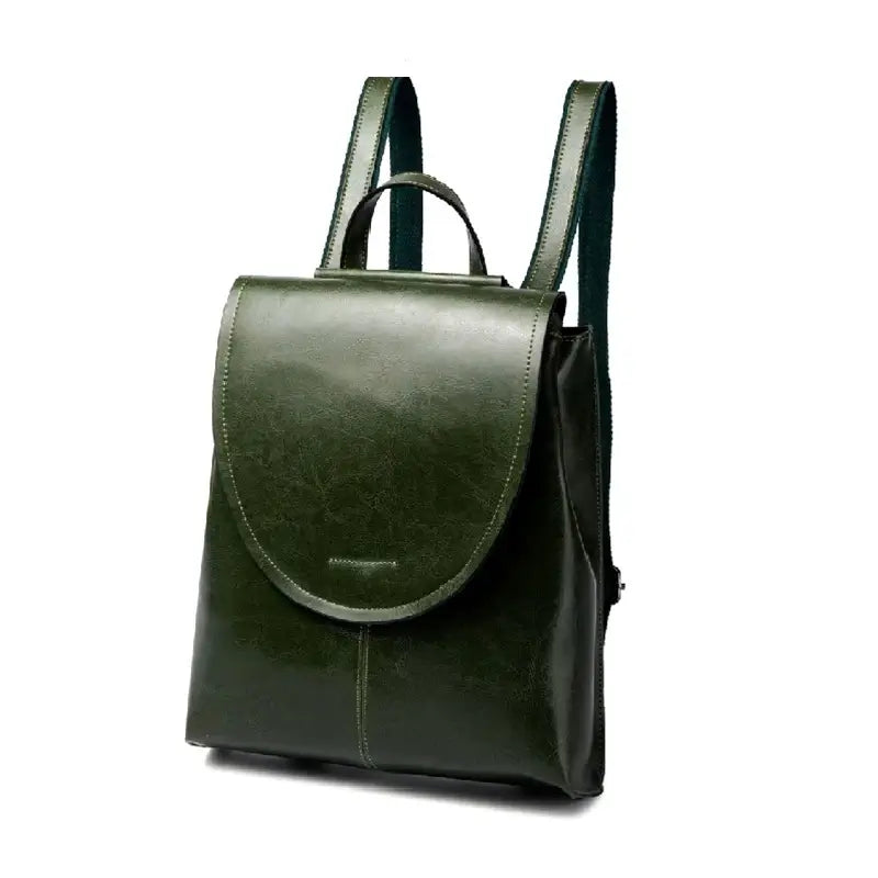 Sac à dos femme en cuir vert foncé en position debout sur fond blanc, avec rabat élégant et bretelles assorties.