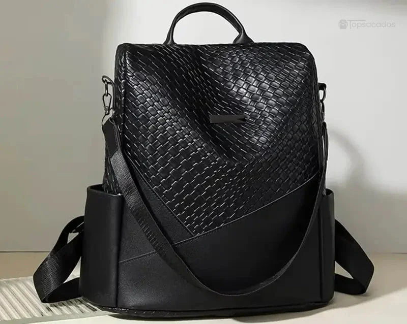 Sac à dos femme noir photographié sur fond neutre, exposant ses détails en relief, sa forme géométrique et sa sangle latérale.