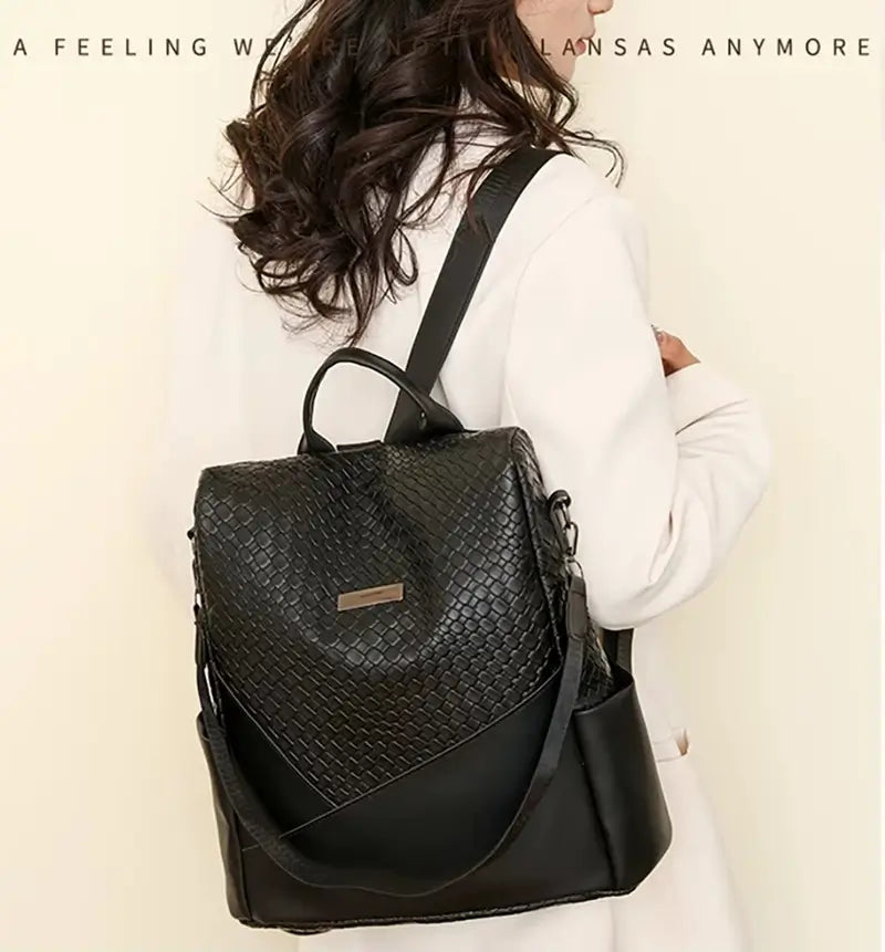 Sac à dos femme noir porté par une femme en manteau clair, mettant en avant son allure chic et son format compact pour la ville.