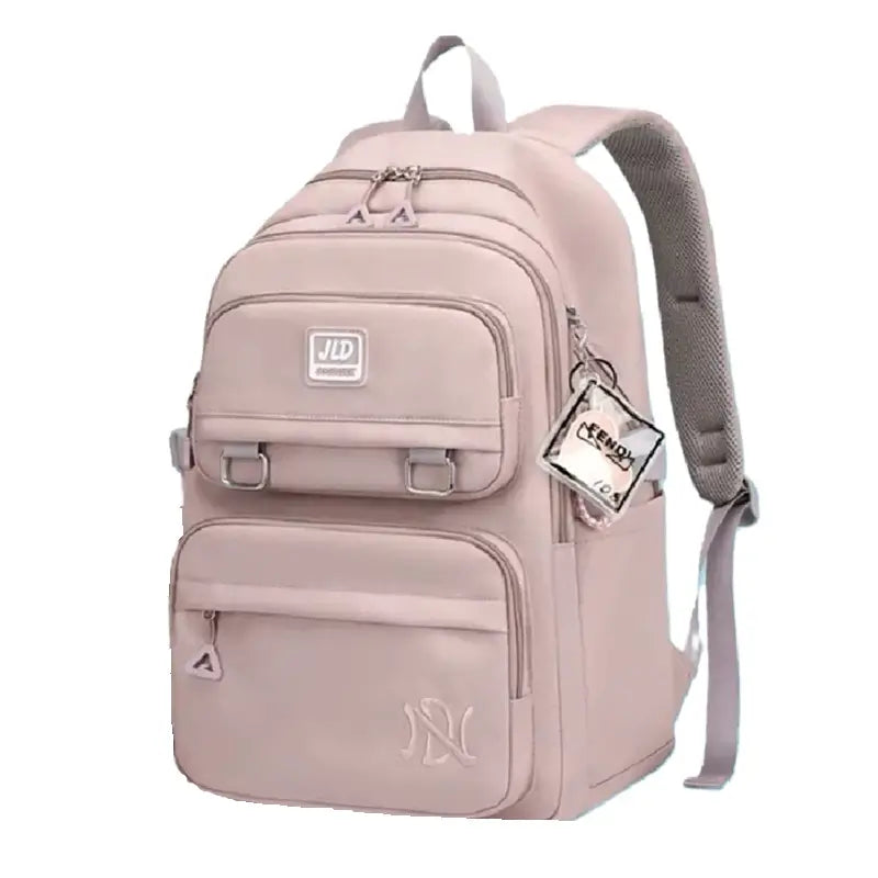 Sac à dos fille rose pâle avec poches multiples et breloque transparente, vu de trois-quarts sur fond blanc
