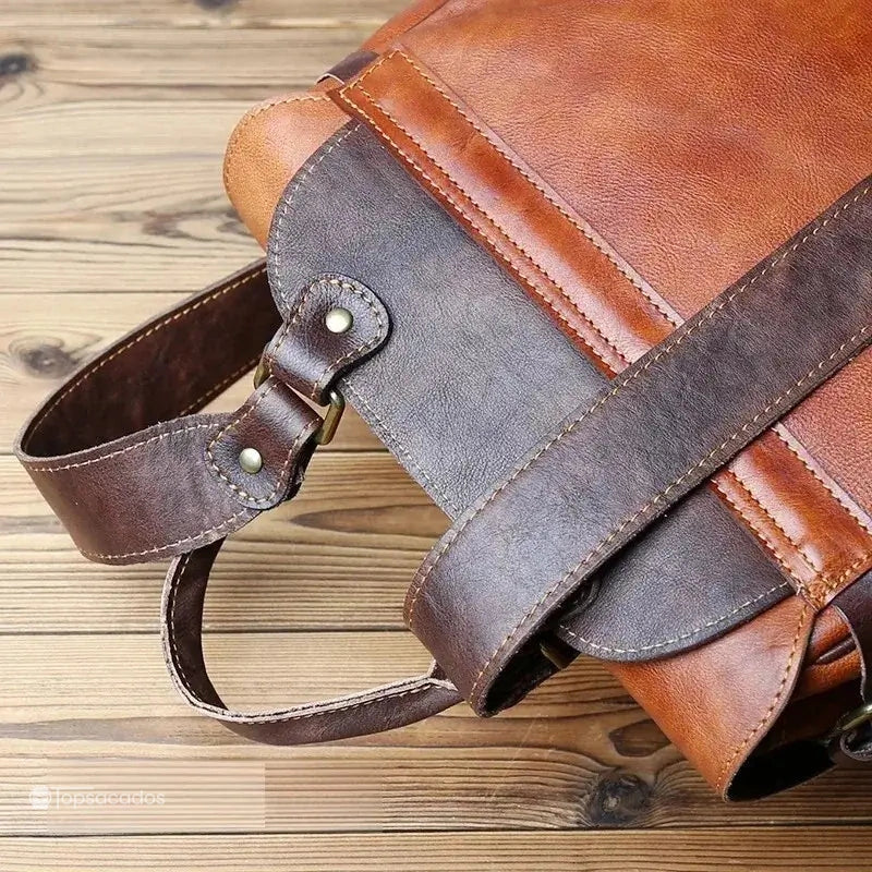 Sac à dos homme cuir vintage en cuir brun vu en détail par dessous, montrant l’ancrage des bretelles et la qualité de l’assemblage.