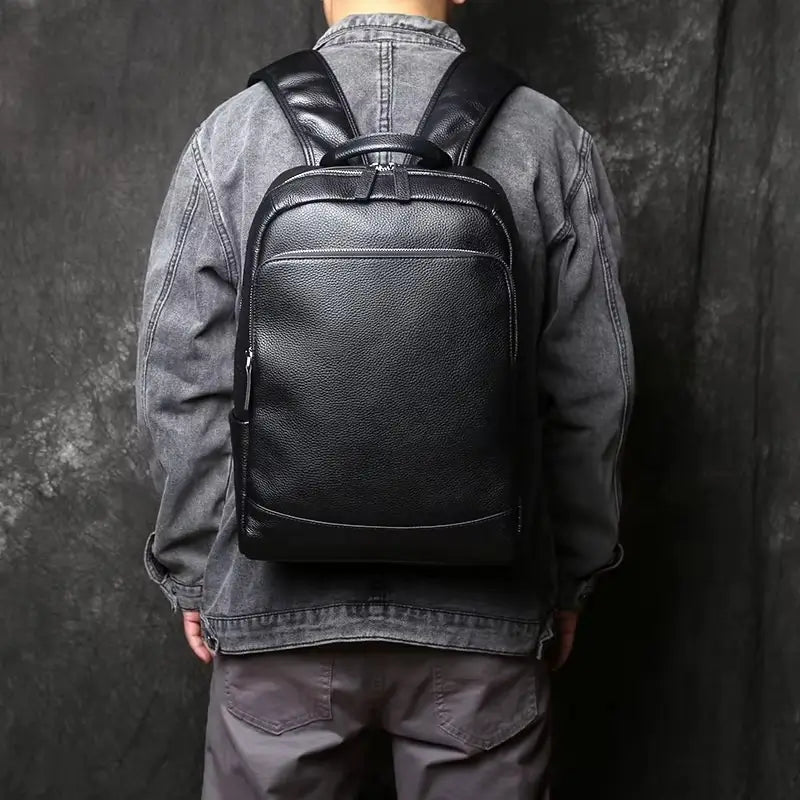 Sac à dos homme cuir - porté sur le dos d’un homme en veste grise, illustrant la taille, le confort et l’allure élégante en situation.