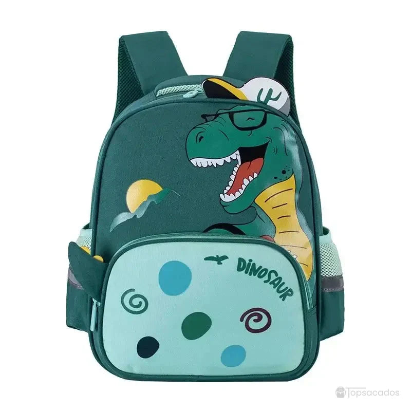 Sac à dos maternelle dinosaure vert avec T-Rex rigolo, lunettes dessinées et motifs ludiques sur la poche frontale.
