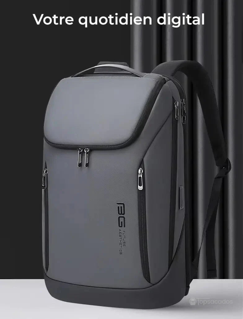 Sac a dos ordinateur portable gris posé devant un rideau noir, avec l’inscription "Votre quotidien digital", soulignant son usage connecté et moderne.
