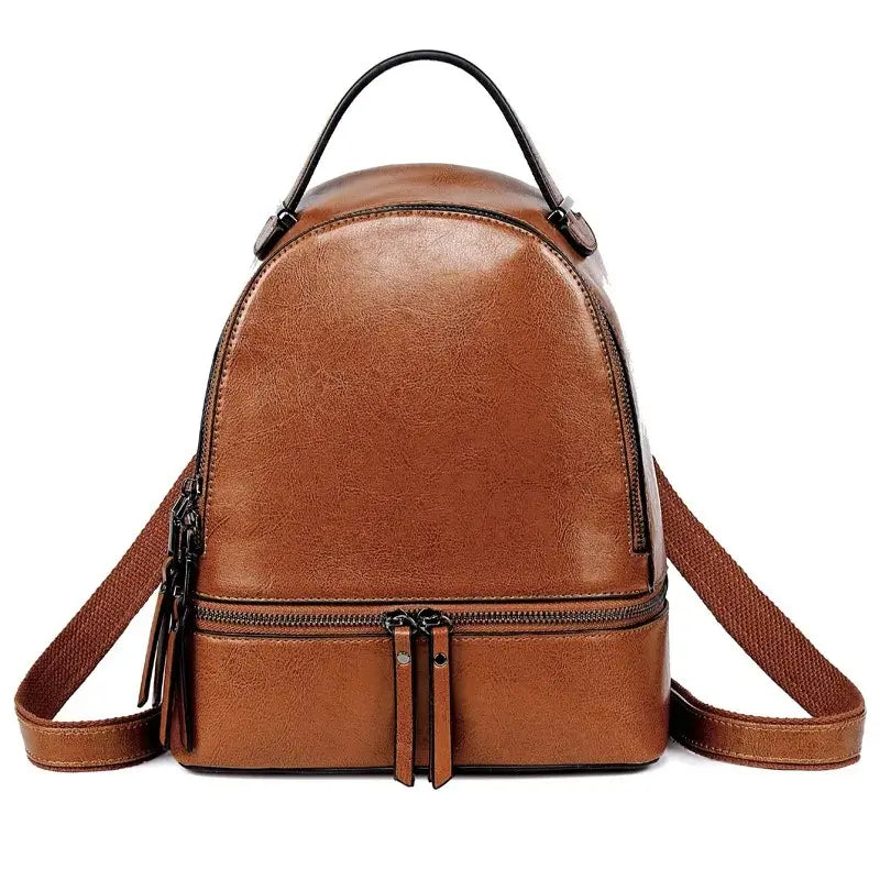 Sac à dos pour femme en cuir marron clair, forme compacte et poignée supérieure, parfait pour un usage quotidien.