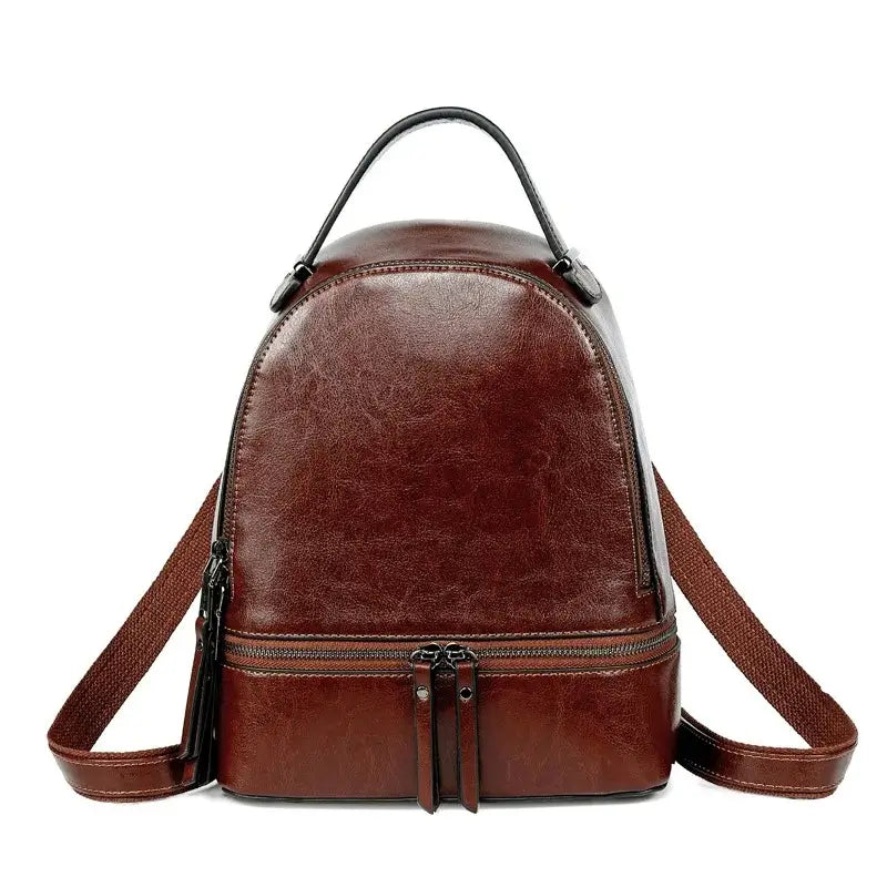 Sac à dos pour femme en cuir marron foncé, doté de deux zips métalliques et de bretelles larges, vu de face.