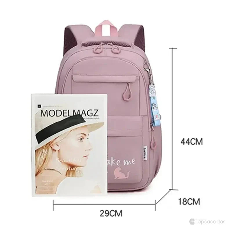 sac a dos primaire rose montré à côté d’un magazine pour référence de taille, 44 cm de hauteur