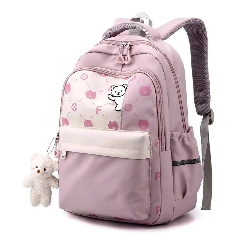 Sac à dos primaire fille rose clair décoré d'un motif ourson blanc, vu de trois quarts avant.