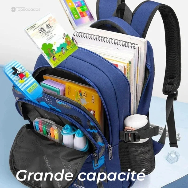 Sac à dos primaire garçon ouvert montrant son contenu scolaire avec trousses, livres, gourde et cahiers, démontrant sa grande capacité