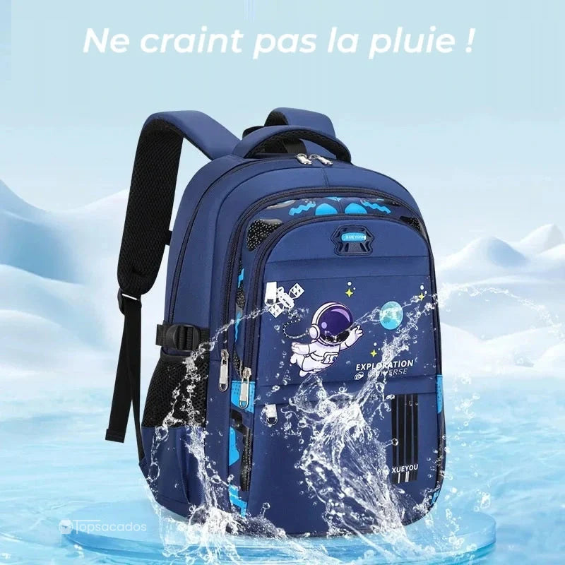Sac à dos primaire garçon bleu en situation d’étanchéité, illustré avec éclaboussures d’eau sur fond glacé et texte ‘Ne craint pas la pluie’