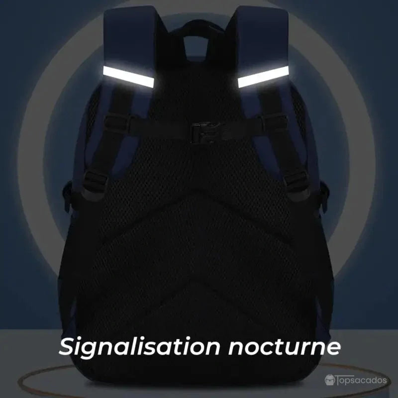 Sac à dos primaire garçon vu de dos dans l’obscurité avec bandes réfléchissantes allumées pour signalisation nocturne