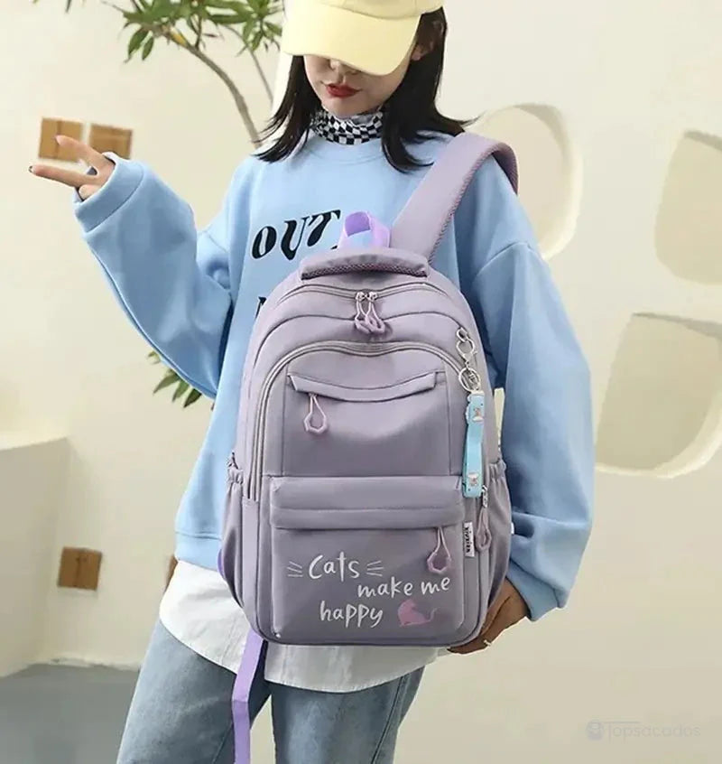 sac a dos primaire violet tenu par une jeune fille en tenue décontractée dans un cadre intérieur lumineux