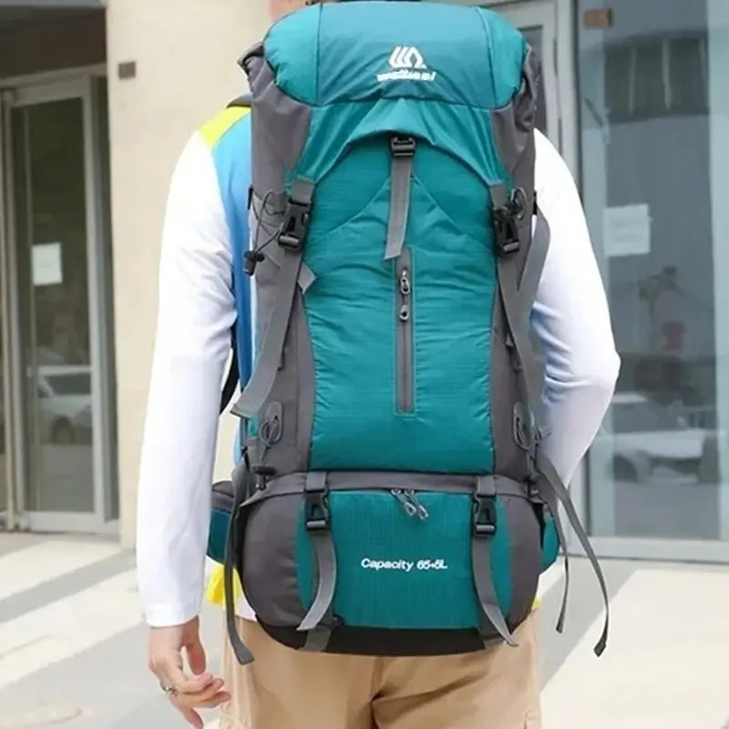 Sac à dos randonnée étanche 65 litres porté par une personne en extérieur urbain, vue de dos avec bretelles rembourrées