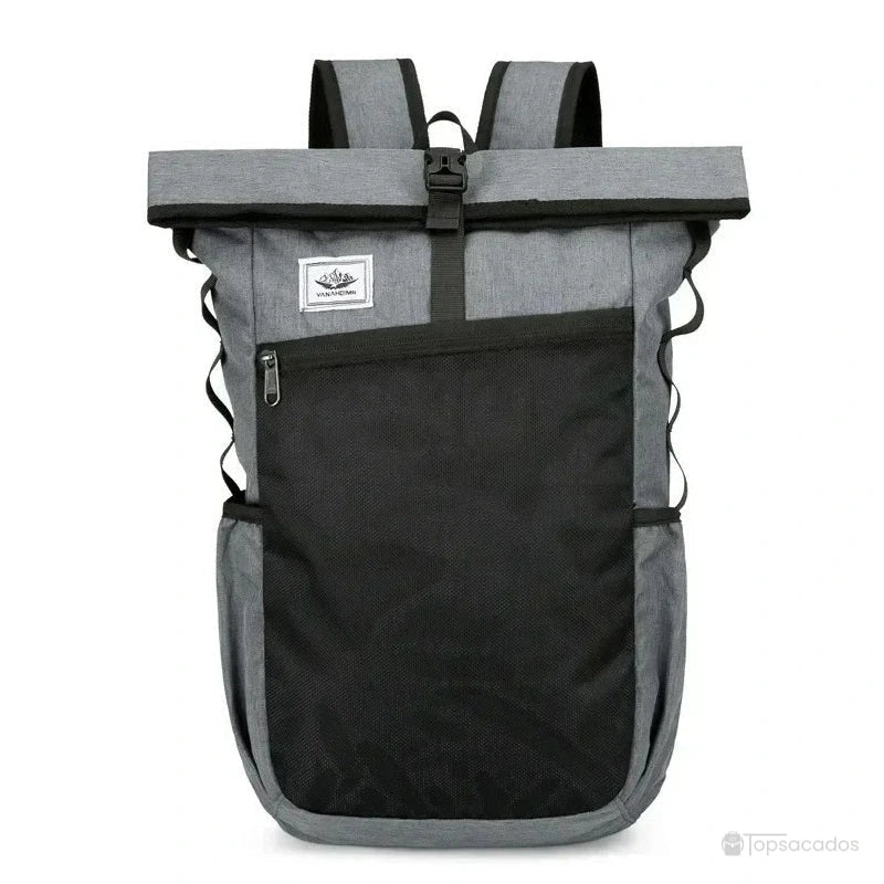 Sac à dos roulé gris foncé avec grande poche noire zippée sur le devant et boucle centrale, présenté en vue de face sur fond neutre.