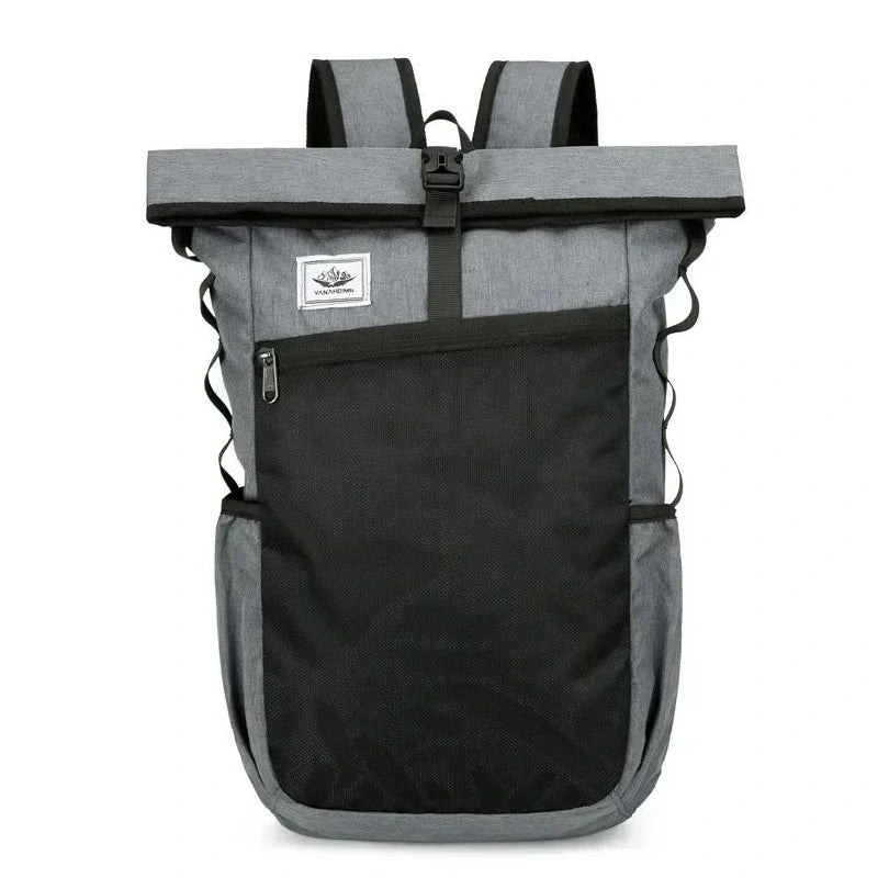 Sac à dos roulé gris foncé avec grande poche noire zippée sur le devant et boucle centrale, présenté en vue de face sur fond neutre.