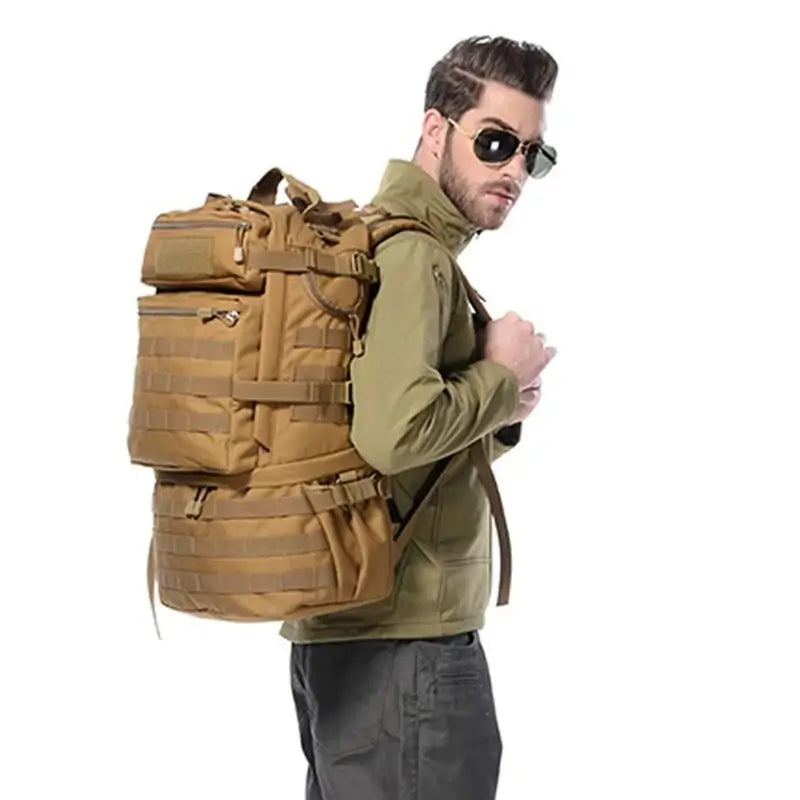 Sac à dos tactique porté par un homme en veste verte et lunettes noires, démontrant son ergonomie et sa taille réelle en situation.