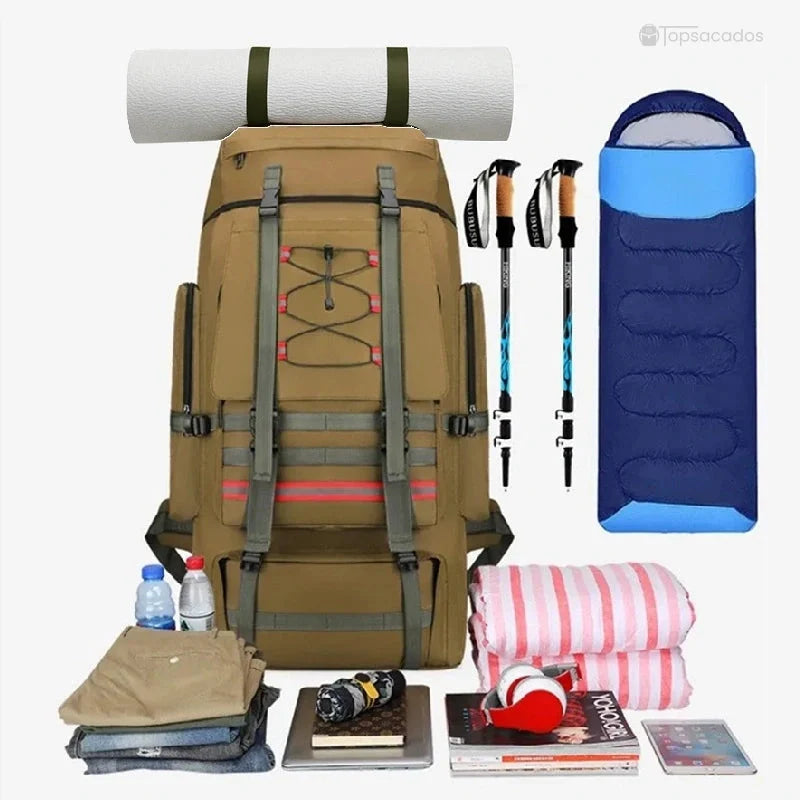 Sac à dos trekking beige présenté avec son contenu de voyage : sac de couchage, matelas, vêtements et accessoires outdoor.