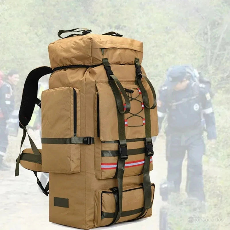 Sac à dos trekking beige porté dans un environnement boisé par un randonneur en mouvement.